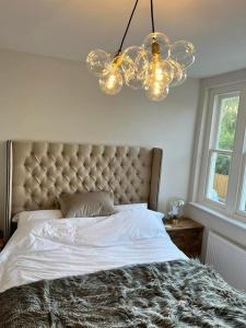 a bedroom with a large bed and a chandelier at Three Acorns Court in Sandwich