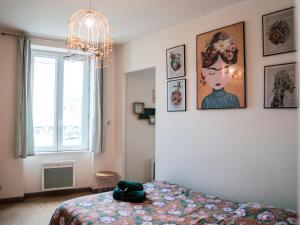 - une chambre avec un lit doté d'un chapeau vert dans l'établissement La Grande Maison Clermont - Appartements centre ville, à Clermont-Ferrand