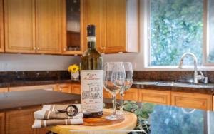 una bottiglia di vino seduta su un tavolo con un bicchiere di vino di LA Dream Gem - Beautiful Home with Spa a Los Angeles