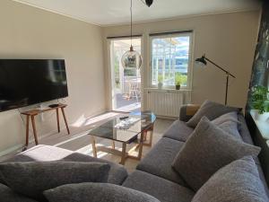 uma sala de estar com um sofá e uma mesa de vidro em Villa med sjöutsikt em Fors