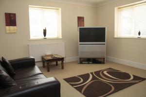 a living room with a couch and a flat screen tv at Wortley House Hotel in Scunthorpe