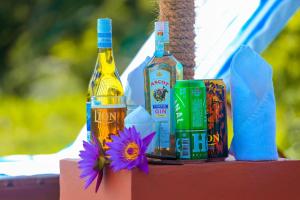 twee flessen alcohol en een bloem op een tafel bij Sigiriya Water Cottage in Sigiriya