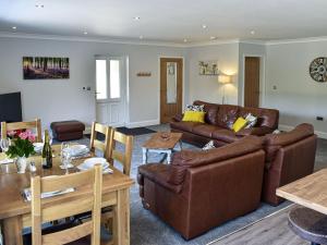 a living room with a couch and a table at Grange Garth Cottage in Acaster Malbis