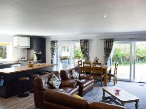 a living room with a couch and a kitchen and a table at Grange Garth Cottage in Acaster Malbis