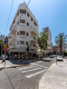特拉维夫1B Patio beach house premium location w/2 balcony的街道上高大的白色建筑,有路标