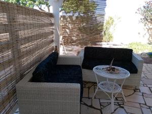a patio with two couches and a table at Finestre Sul Mare Salento - Case Vacanze in Punta Prosciutto