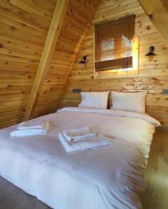 a bed in a log cabin with towels on it at Sapanca Havuzlu jakuzili süit Bungalov in Sapanca