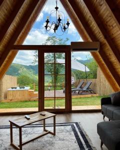 ein Wohnzimmer mit einem Tisch und einem großen Fenster in der Unterkunft Sapanca Havuzlu jakuzili süit Bungalov in Sapanca