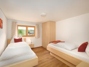 1 dormitorio con 2 camas y ventana en Felder Apartments, en Schoppernau