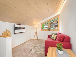 uma sala de estar com um sofá vermelho e uma mesa em Felder Apartments em Schoppernau