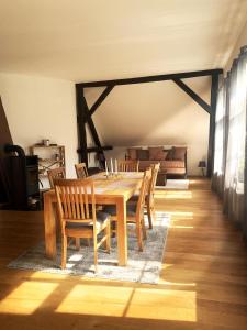 a dining room with a wooden table and chairs at Kastanienhof in Südbrookmerland