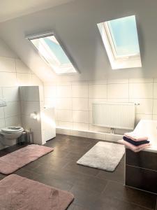 baño con 2 ventanas, aseo y alfombras en Kastanienhof, en Südbrookmerland