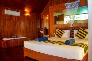 Schlafzimmer mit einem großen Bett und einem Fenster in der Unterkunft Sigiriya Water Cottage in Sigiriya