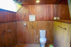 e bagno in legno con servizi igienici e doccia. di Sigiriya Water Cottage a Sigiriya