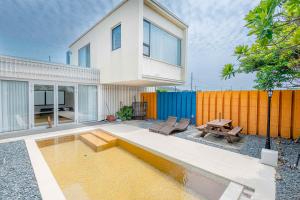 uma casa com uma piscina em frente a uma cerca em Boutique Pool Villa NAMIB em Jeju