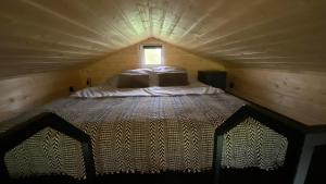 duże łóżko w małym pokoju z oknem w obiekcie Brzozowisko Zalewo w mieście Miłomłyn