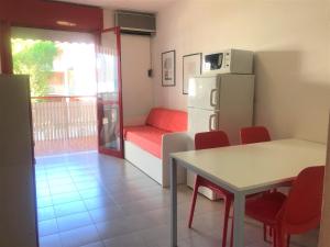 a room with a refrigerator and a table and chairs at Gabbiano - Appartamenti in Bibione