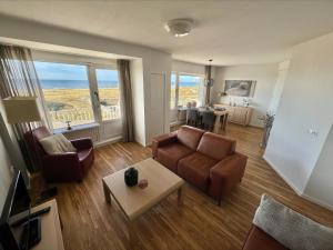 a living room with a couch and a table at Appartementen Zeezicht - 3 in Katwijk aan Zee