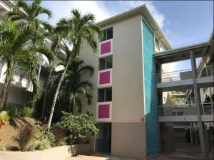 un bâtiment avec des palmiers devant dans l'établissement Grand bleu-Superbe T2 vue mer & accès plage, au Gosier 10 autres photos