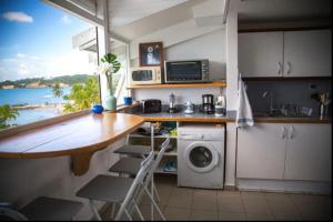 une cuisine avec une table et un comptoir avec une fenêtre dans l'établissement Grand bleu-Superbe T2 vue mer & accès plage, au Gosier