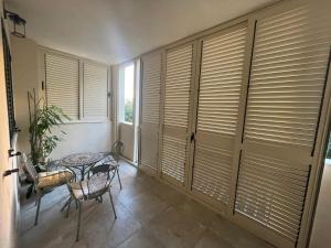 a room with wooden blinds and a table and chairs at Anna Apartments in Split