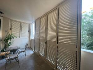 a room with wooden blinds on a wall with a table and chairs at Anna Apartments in Split