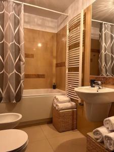 łazienka z umywalką, toaletą i wanną w obiekcie Apartament Stella Baltic w Świnoujściu