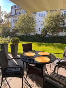 patio ze stołem, krzesłami i trawnikiem w obiekcie Apartament Stella Baltic w Świnoujściu
