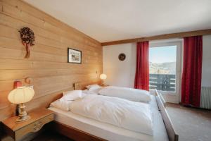 een slaapkamer met een bed en een raam bij Hotel Pradell in Ortisei