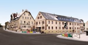 a group of buildings on the corner of a street at Braugut Hartmannsdorf in Hartmannsdorf