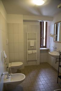 a bathroom with two toilets and two sinks and a window at Albergo Reale in Roccaraso