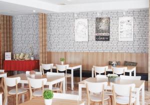 a restaurant with tables and chairs and a brick wall at Hans Inn Batam in Nagoya