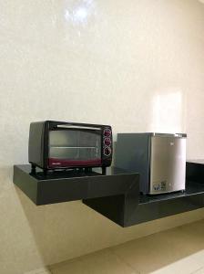a microwave and a toaster oven on a shelf at Hans Inn Batam in Nagoya