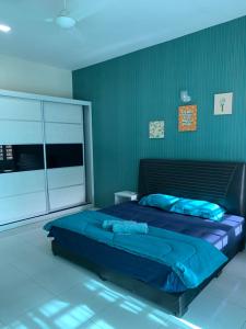 a bedroom with a large blue bed in a room at ZillQayyim Homestay in Seri Iskandar