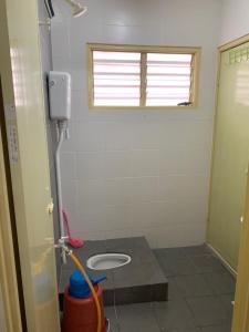 - une salle de bains avec toilettes dans une chambre avec fenêtre dans l'établissement ZillQayyim Homestay, à Seri Iskandar