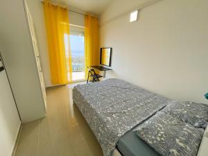 a bedroom with a bed and a television and a window at Apartmani Tanja in Dramalj