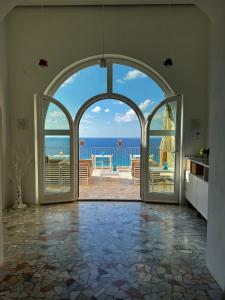 uma porta aberta para um quarto com vista para o oceano em La Dolce Vita a Tropea em Tropea