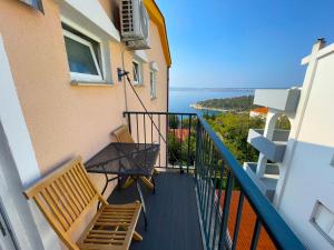 a balcony with a bench and a view of the ocean at Apartmani Tanja in Dramalj
