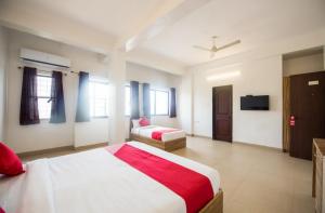 a large bedroom with a bed and a couch at Primrose Guest House in Pune