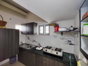 a kitchen with a sink and a stove in it at Comfy 2-bedroom House in Sanjaynagar, Bengaluru in Bengaluru