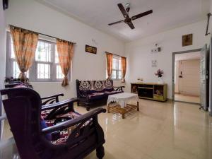 a living room with a ceiling fan and a couch at Comfy 2-bedroom House in Sanjaynagar, Bengaluru in Bengaluru