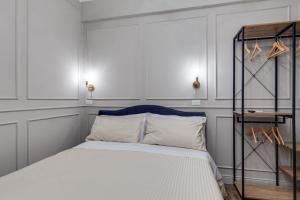 1 dormitorio con cama blanca y cabecero azul en Vogue Suites Rome en Roma