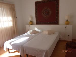 a bedroom with two beds and a picture on the wall at HI Tavira – Pousada de Juventude in Tavira