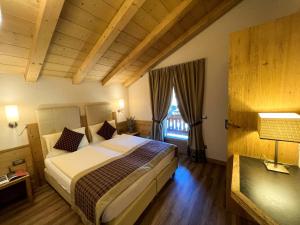 a bedroom with a large bed and a window at Casa Meta in Livigno