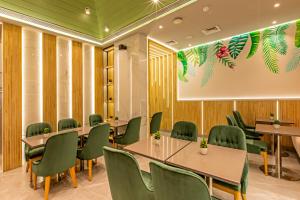 a conference room with tables and green chairs at Hotel Bawa Suites in Mumbai