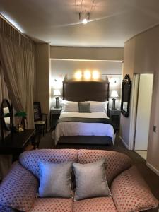 a bedroom with a bed with a couch in front of it at 504 Mapungubwe Hotel in Johannesburg