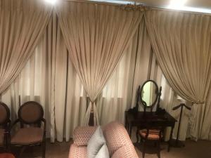 a living room with curtains and a couch and a mirror at 504 Mapungubwe Hotel in Johannesburg