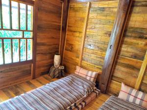 Habitación con 2 camas en una habitación con paredes de madera. en Retreat Home Bản Dọi Mộc Châu en Mộc Châu