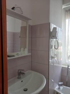 een witte badkamer met een wastafel en een spiegel bij Villa Silvia b&b in Marina di Camerota