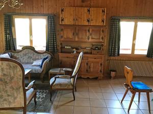 a living room with wooden cabinets and a table and chairs at Les Tchaipus in Nendaz